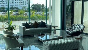 A modern living room with a sofa, armchairs, a coffee table, and a patterned armchair. - Bay Win La.mer Butik (Kota Kinabalu)