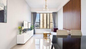A modern living room with a dining table, sofa, and a view of high-rise buildings. - MIN' Apartment - Rivergate Residence Downtown BUI VIEN - FREE POOL (Ho Chi Minh City)