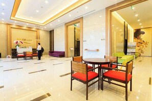 A hotel lobby with a reception desk, seating area, and a large window. - MIN' Apartment - Rivergate Residence Downtown BUI VIEN - FREE POOL (Ho Chi Minh City)