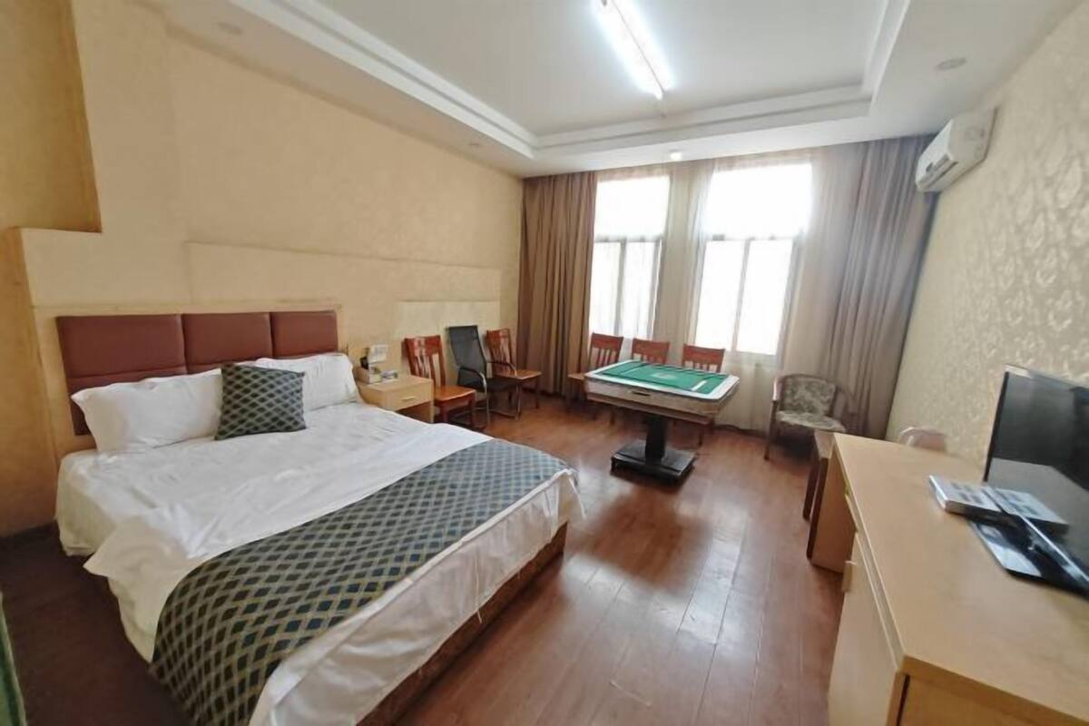 Una habitación de hotel con cama, escritorio, mesa de billar y televisor.