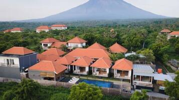 A resort with multiple buildings, a swimming pool, and a mountain in the background.