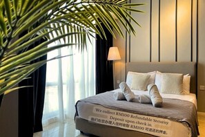 A hotel room with a bed, a lamp, and a large plant. - Axon Bukit Bintang by Janice's Homestay (Kuala Lumpur)