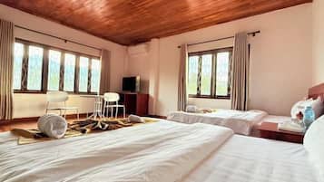 Habitación de hotel con dos camas, televisor, escritorio y una silla.