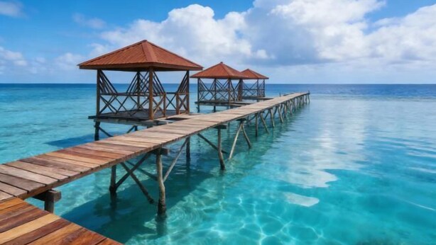 A wooden pier extending into clear turquoise water, supported by wooden pillars, with two overwater bungalows at the end. - Turtle Garden Resort @ Semporna (Semporna)