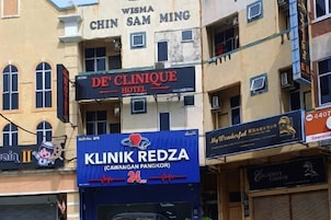 A multi-story building with various commercial establishments, including a hotel and a clinic.