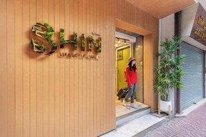 Une devanture de magasin portant l’inscription « SHIN » et une personne qui entre.