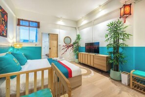 A modern living room with a bed, a TV, a plant, and a wooden cabinet. - Shin Hotel Chinatown (Bangkok)