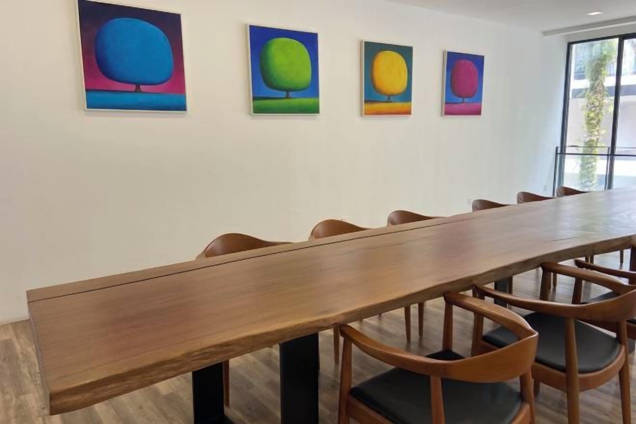 A conference room with a long wooden table and six chairs.