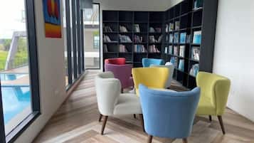 A modern interior with a large bookshelf, a pool view, and a herringbone floor pattern.