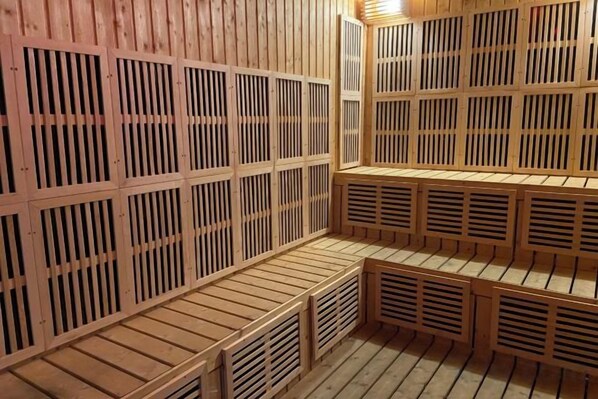 A sauna with wooden benches and slatted walls. - Gala Residences @ Galacity (Kuching)