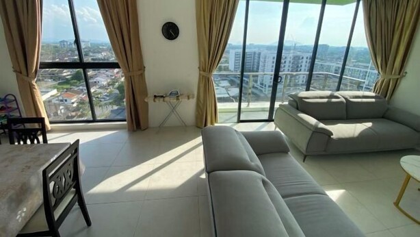 Un salon comprenant un canapé, une table à manger et offrant une vue sur le paysage urbain grâce à de grandes fenêtres.