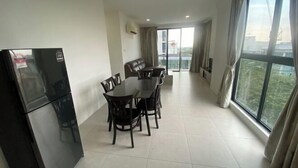 Un appartement moderne doté d’un coin repas, d’un réfrigérateur et d’un balcon avec vue.