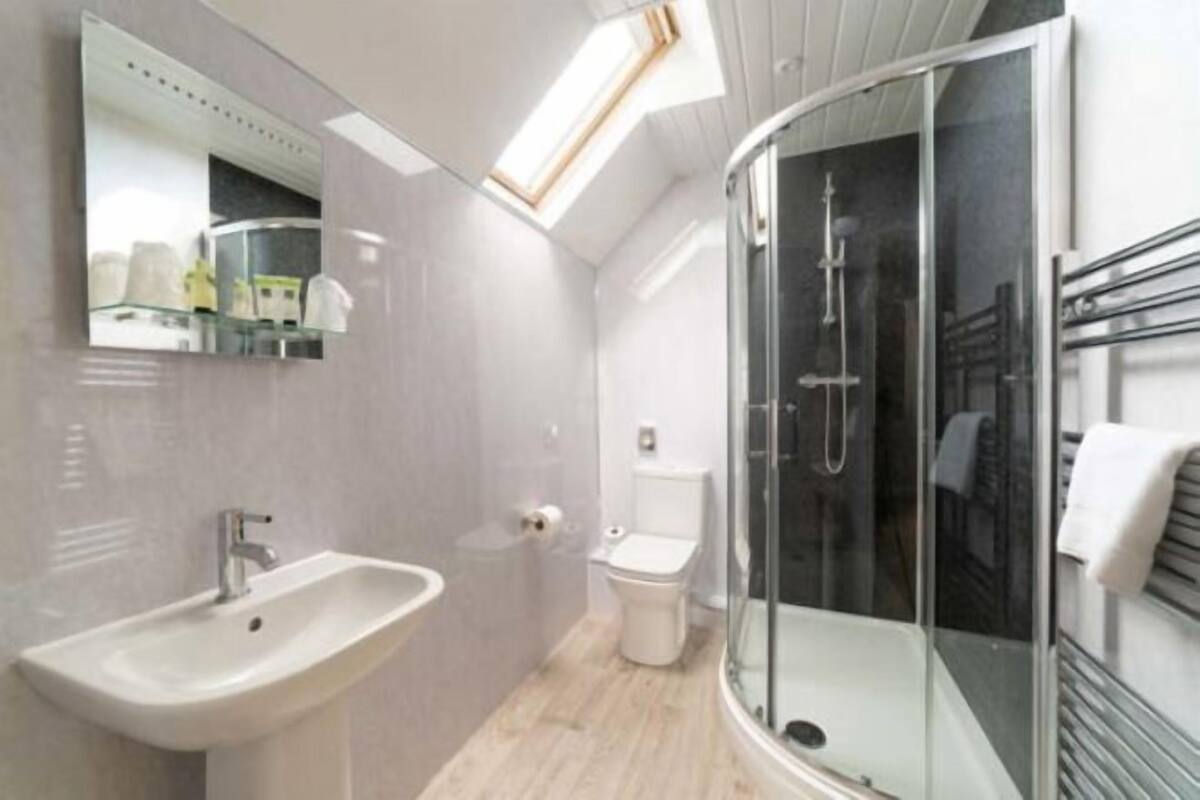 Une salle de bain moderne avec une douche à parois de verre, un lavabo et des toilettes.