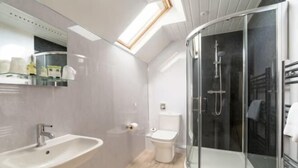 Une salle de bain moderne avec une douche à parois de verre, un lavabo et des toilettes.