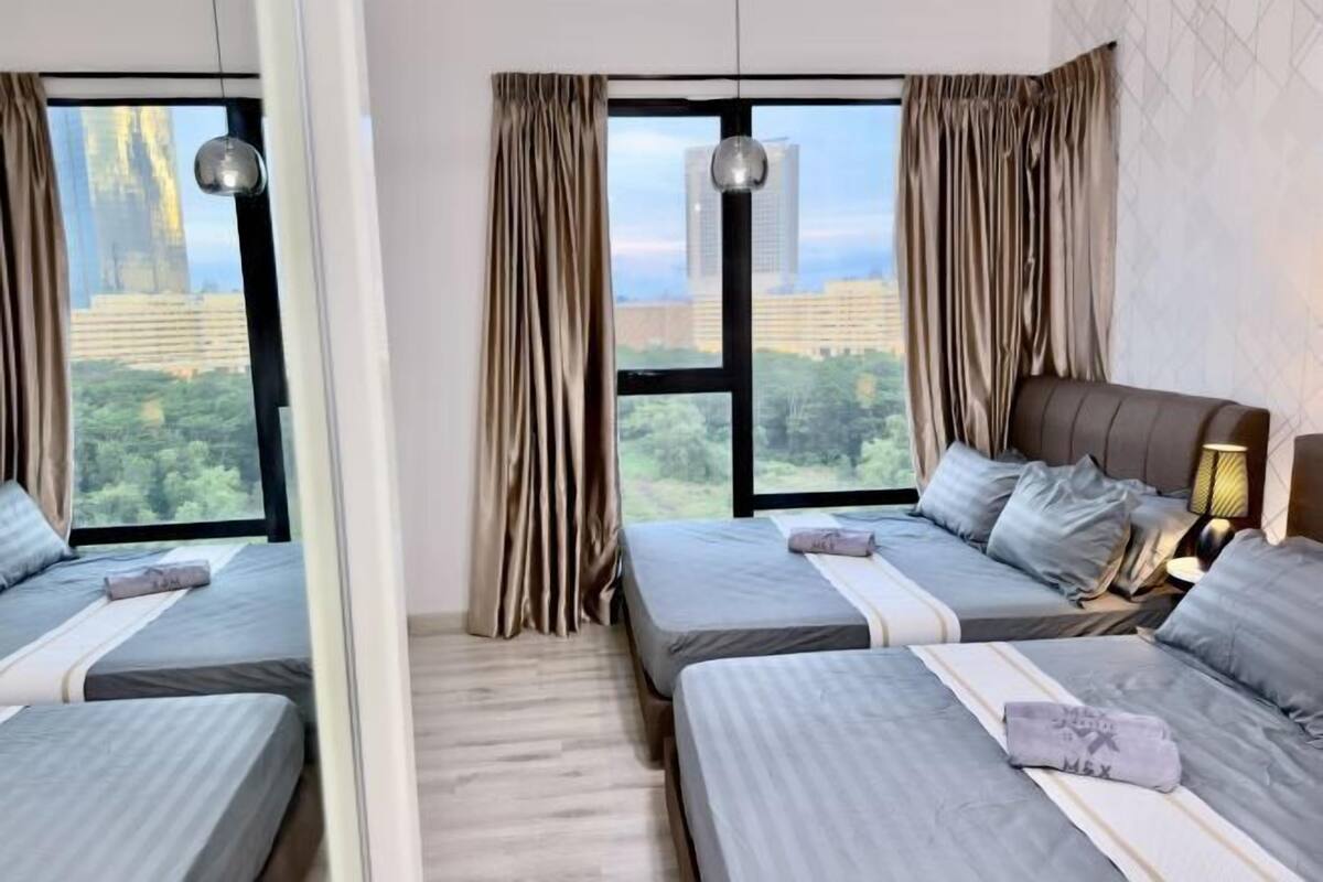 A hotel room with two beds, large windows with curtains, a city view, and a modern lamp.