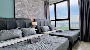 Une chambre d’hôtel avec deux lits, un mur en pierre, une grande fenêtre avec des rideaux et une vue sur la ville.