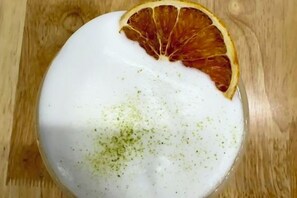 Een ronde witte vorm met een gedroogd sinaasappelschijfje erop, geplaatst op een houten ondergrond.
