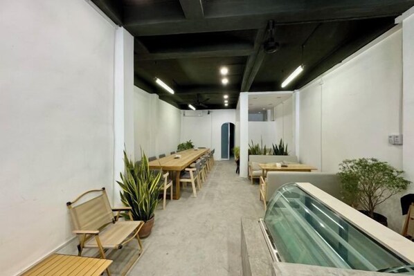 Een vergaderzaal met een lange tafel, stoelen en potplanten.