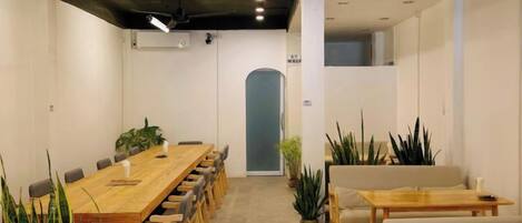 A conference room with a long table, chairs, and potted plants.