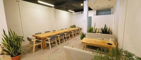 A conference room with a long table, chairs, and potted plants.