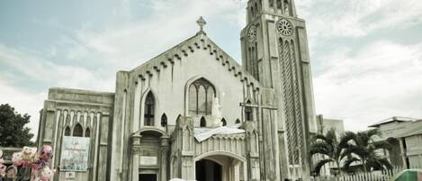 Una iglesia grande con una torre de reloj destacada y una entrada central.