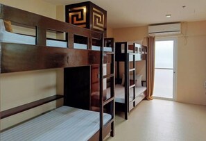 A room with bunk beds, a door, and an air conditioning unit. - Hotel Juliana by RedDoorz (Tuguegarao)