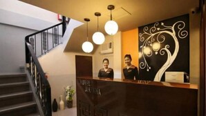 Una recepción de hotel con diseño moderno, una escalera e iluminación decorativa.