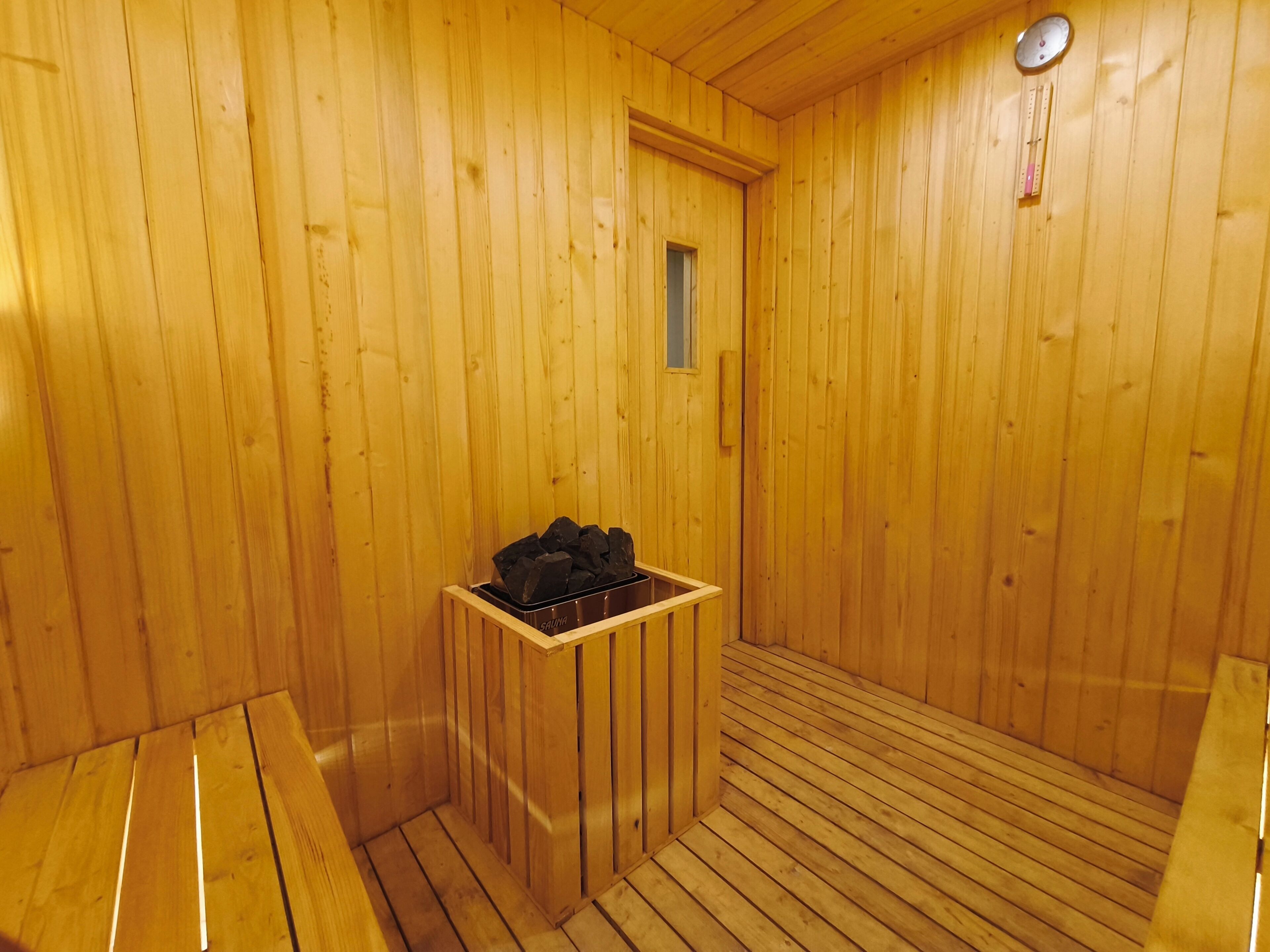 A sauna room with wooden walls and a bench.