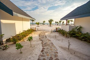 A pathway leading to a beach with palm trees and a clear sky. - You Me Resort (Koh Rong)