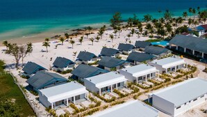 A beachfront hotel with multiple rooms, a sandy beach, and palm trees. - You Me Resort (Koh Rong)