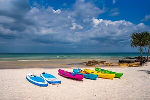 A beach with kayaks and a tree. - You Me Resort (Koh Rong)