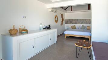 Een slaapkamer met een bed, nachtkastje en een klein krukje.
