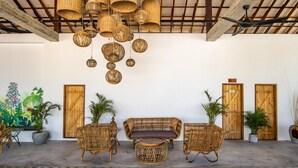 A room with wicker furniture, hanging baskets, and wooden doors. - You Me Resort (Koh Rong)