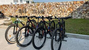 A row of bicycles parked against a stone wall.