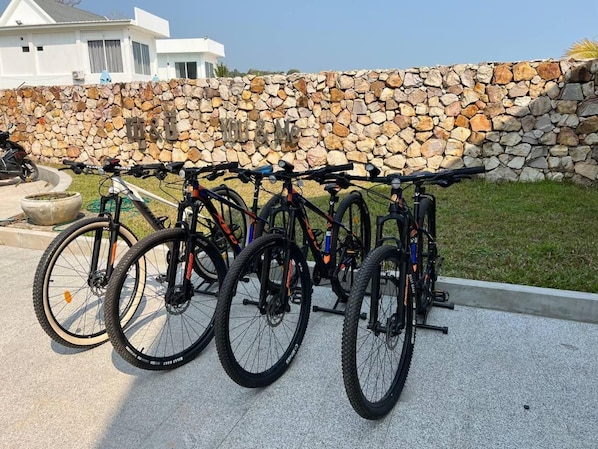 Una hilera de bicicletas estacionadas junto a un muro de piedra.