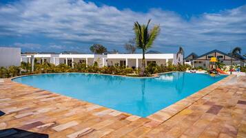 A swimming pool with a tiled deck, surrounded by buildings with a modern architectural style.