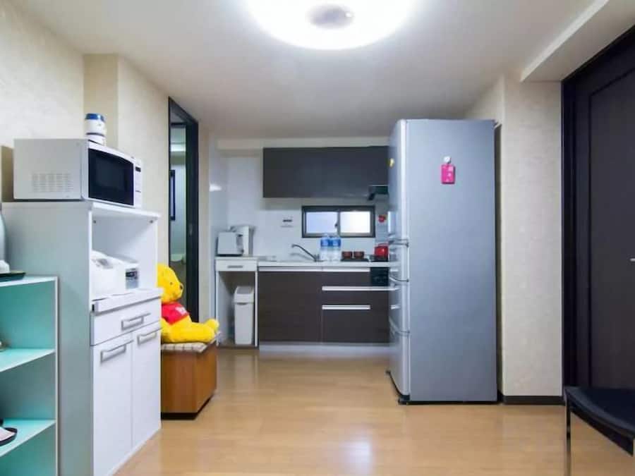 A compact kitchen with a microwave, refrigerator, and a sink.