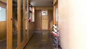 Un corridoio con porte in legno, una scala e un port scarpe.
