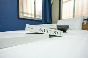 A neatly made bed with a white pillow and a white box labeled 'ASSOULES' on it.