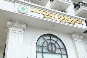 Un edificio con un letrero que dice 'LUCKY PHOENIX HOTEL & APARTMENTS'.