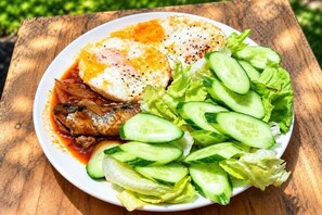A plate of food with eggs, fish, and vegetables.