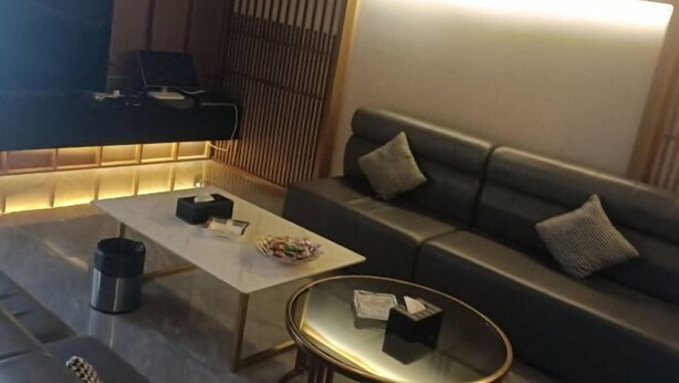 A modern living room with a sofa, a coffee table, and a television. - Good Luck Hostel (Phnom Penh)