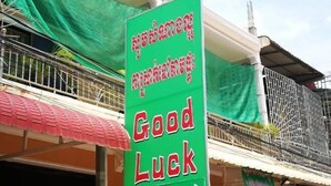 A green sign with red text reading "Good Luck Hotel" in English and another language. - Good Luck Hostel (Phnom Penh)