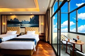 A hotel room with two beds, a balcony with a chair, and a large window with a mountain view.