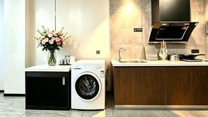 Eine moderne Küche mit Waschmaschine, Spüle und Flachbildfernseher.
