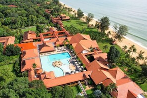 An aerial view of a resort with a swimming pool, beach, and palm trees. - Club Med Cherating Beach (Balok)