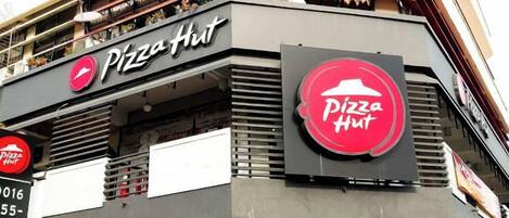 Un restaurante Pizza Hut con un letrero llamativo, un balcón y un escaparate.