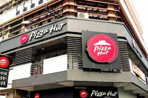 A Pizza Hut restaurant with a prominent sign, a balcony, and a storefront. - MB Hotel (Kota Kinabalu)