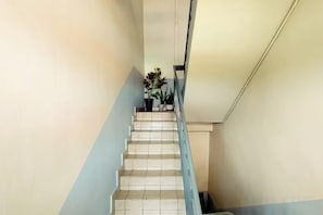 A staircase with a handrail, leading upwards, and a potted plant at the top. - MB Hotel (Kota Kinabalu)