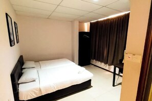 A hotel room with a bed, a desk, and a wardrobe. - MB Hotel (Kota Kinabalu)